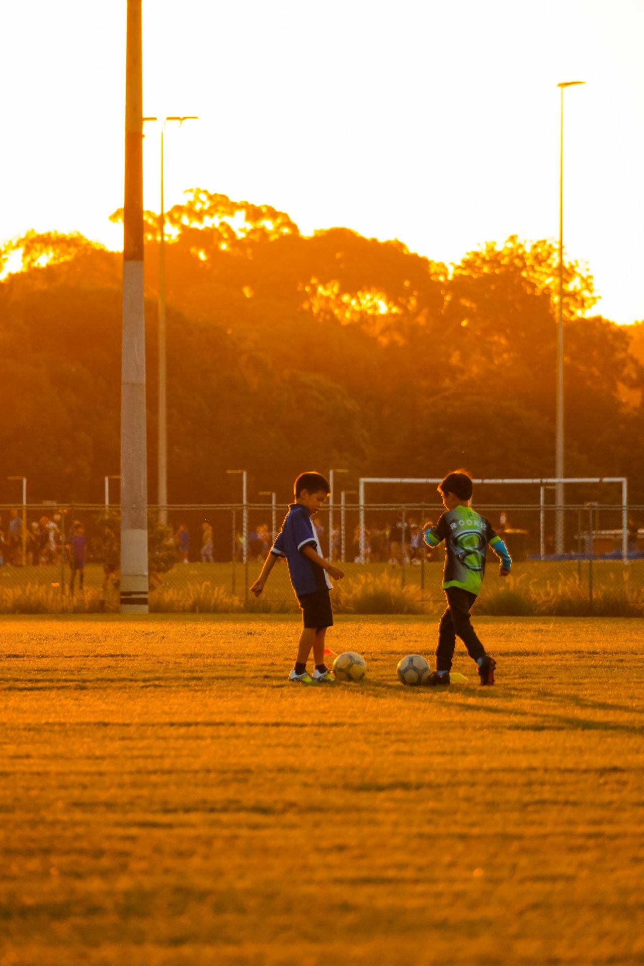 Crianças jogando futebol ao pôr do sol